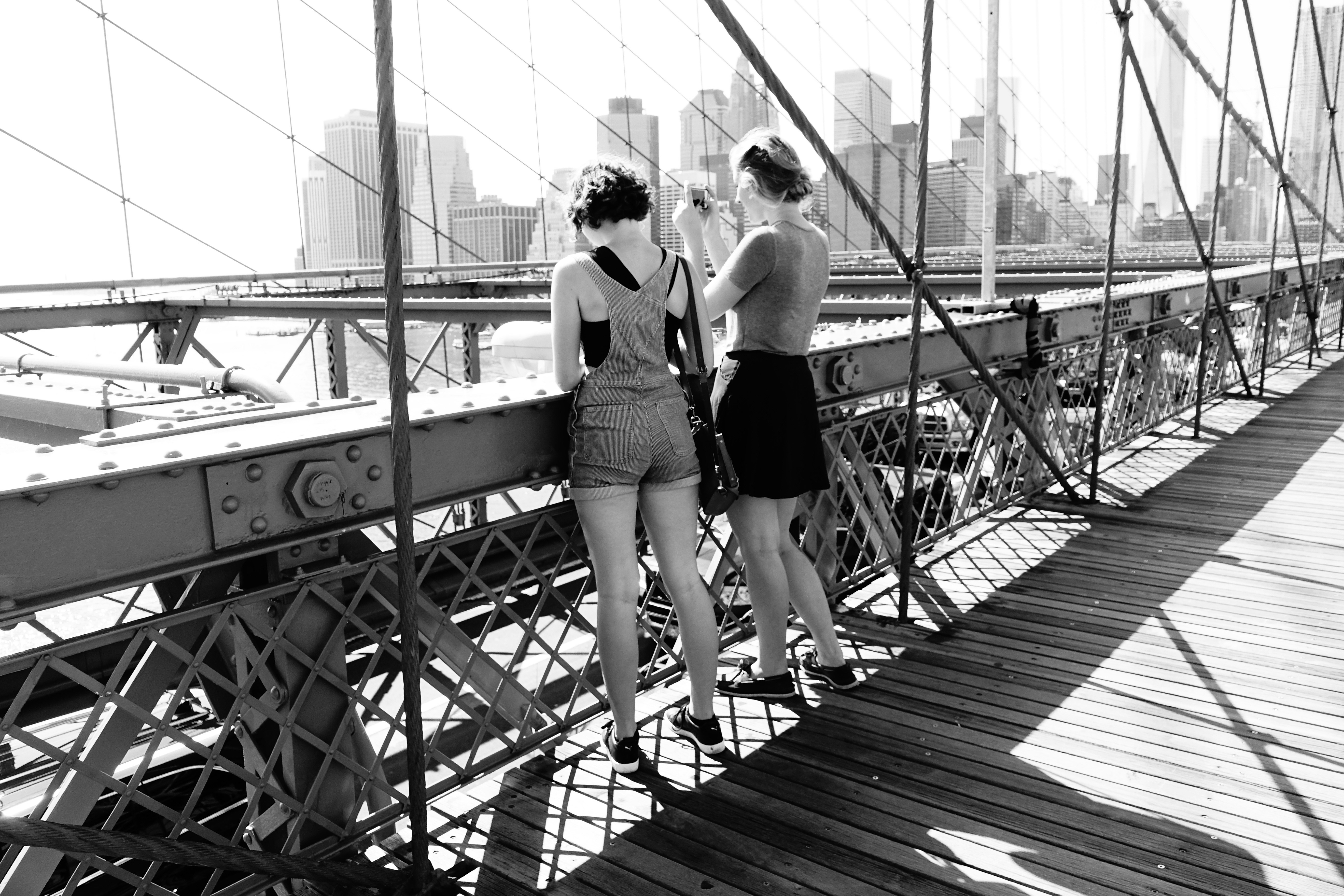 two women standing on bridge